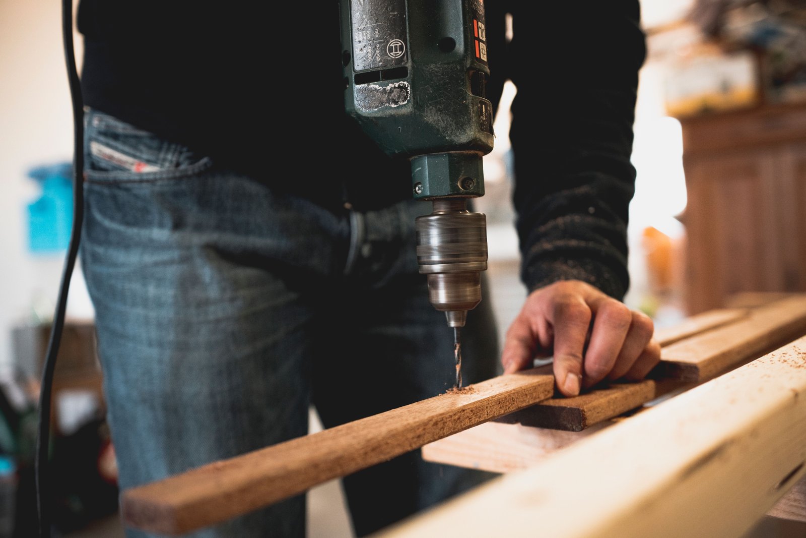 Handy Helpers technician using a drill during a home repair project